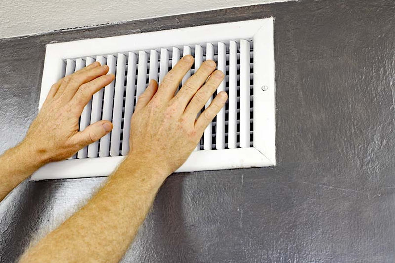 Homeowner feeling hot air coming out of vent from his air conditioner.