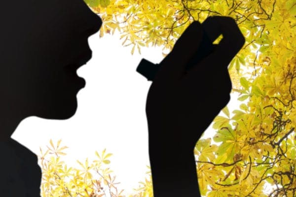 Silhouette of person using an inhaler to represent how ventilation will help asthma attacks.