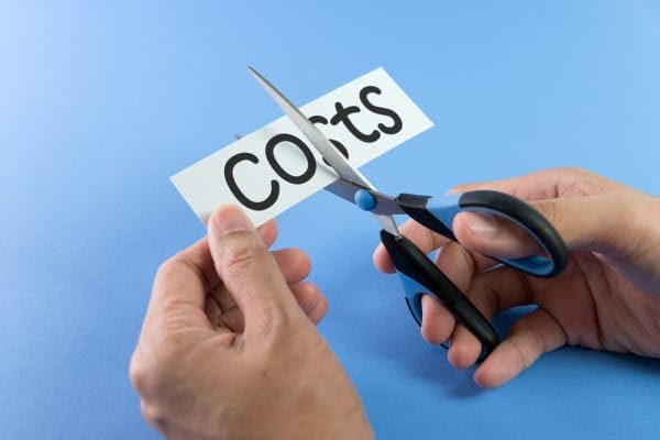 Person cutting up a costs sign to represent three ways you can cut your heating costs.