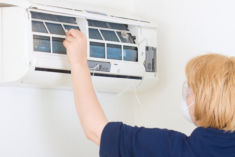 HVAC technician performing maintenance on ductless system.