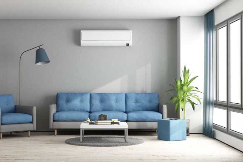 Mounted ductless mini split above couch in living room.