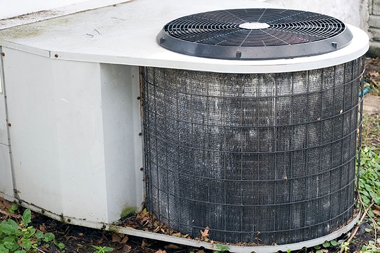 Old air conditioning unit representing three signs you need a new AC.