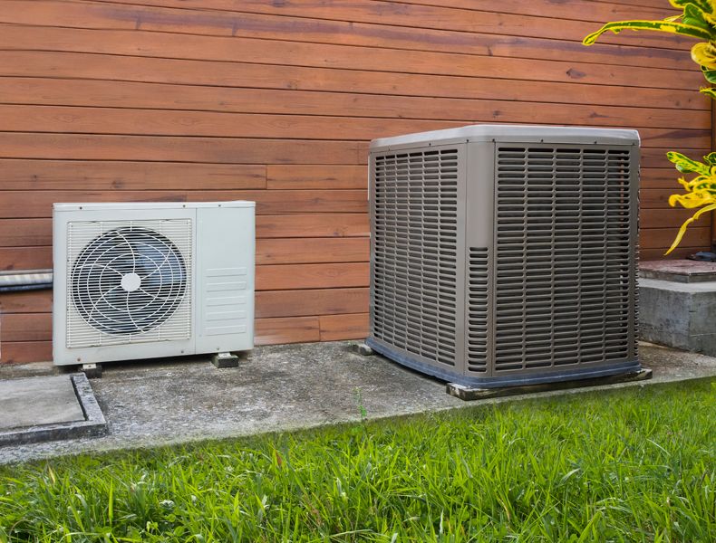 Outdoor heat pumps on concrete pad to represent when it is the best time to buy.