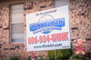 Company yard sign for Winkelman Heating & Air Conditioning, outside Dumas, TX, home.