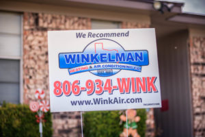 Company yard sign for Winkelman Heating & Air Conditioning, outside Dumas, TX, home.