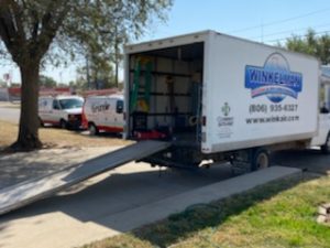 Winkelman Heating & Air Conditioning service vehicle at residential home in Dumas, TX.