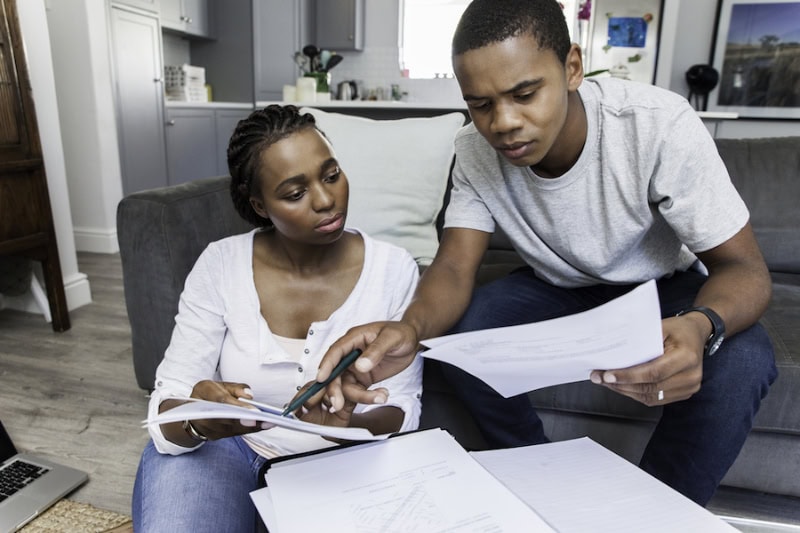 Couple reading a guide about common 2025 refrigerant questions.