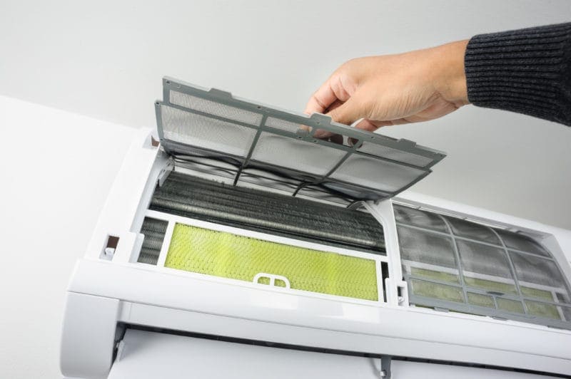 Ductless filter being replaced in a mounted mini split.