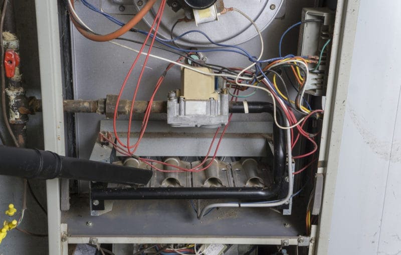 Winkelman Heating & Air Conditioning technician performing furnace maintenance in Dumas, TX.