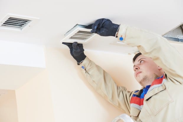 HVAC technician adding a ventilation system in room of Dumas, Texas, home.
